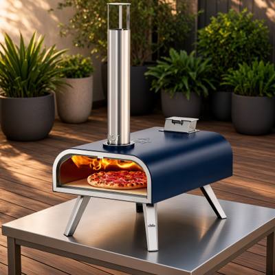 Big Horn 16-inch navy pizza oven on a steel table on a timber deck, fire lit and a pizza on the stone
