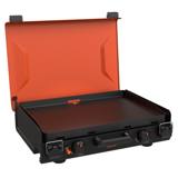 Blackstone 2363 camping griddle open, orange hood raised over an empty black coated plate, two knobs on the front