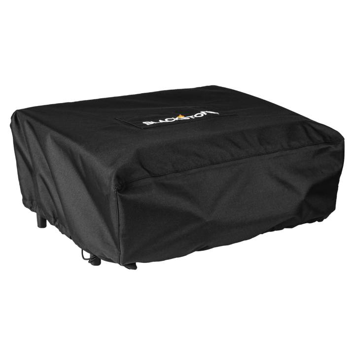 Black Blackstone 1724 cover drawn over a 22 inch tabletop griddle, Blackstone patch on its top