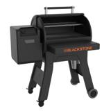Black Blackstone 900 pellet grill with its hood rolled back, two wire racks inside and the hopper on the left