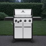 Broil King Crown S 440 with a stainless lid and cabinet doors, black shelves out, four knobs and a side burner knob