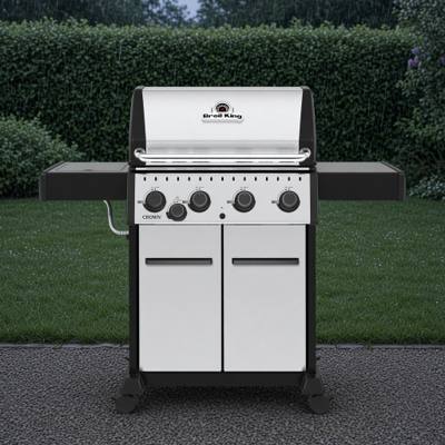 Broil King Crown S 440 with a stainless lid and cabinet doors, black shelves out, four knobs and a side burner knob