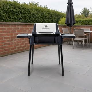Broil King Porta-Chef 120 portable gas grill, lid closed, black cast cook box with stainless lid face, standing on four black snap-in legs