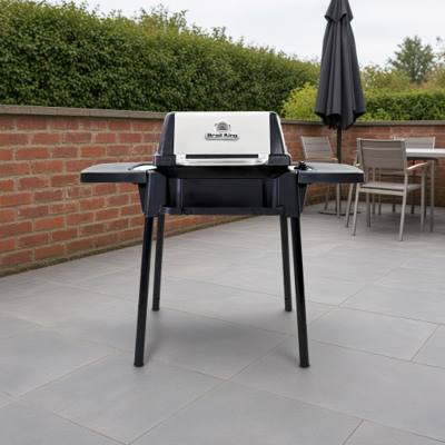 Broil King Porta-Chef 120 portable gas grill, lid closed, black cast cook box with stainless lid face, standing on four black snap-in legs