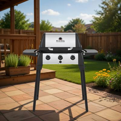 Broil King Porta-Chef 320 portable gas grill on a deck, lid closed, black cast cookbox with stainless lid insert and drop-down side shelves, seen from the front left