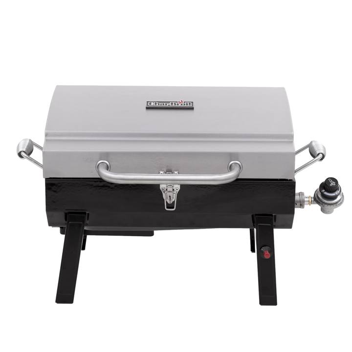 Char-Broil 465640214 portable gas grill, stainless lid latched shut, standing on its folding legs behind a van