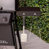 Close-up of the Char-Broil grill's black painted side shelf with a spatula and tongs on its two tool hooks