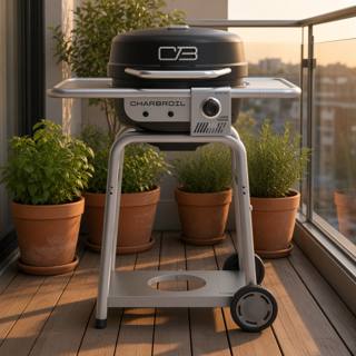 Char-Broil Bistro Pro on a wooden balcony deck, black lid closed, silver shelves and cart, glass railing behind