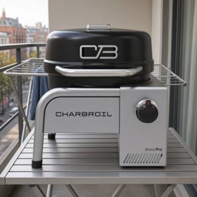 Char-Broil Bistro Pro tabletop gas grill on a balcony table, black lid closed, silver body with one control knob