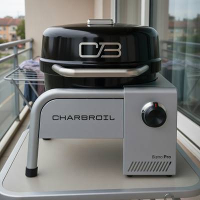 Char-Broil Bistro Pro tabletop gas grill on a balcony table, black lid closed, silver body with one control knob