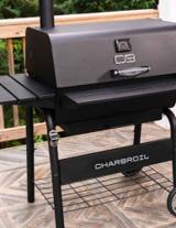 Char-Broil C-Line 840 standing on a wooden deck, lid closed, lid thermometer and CB badge in view