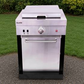 Char-Broil Medallion griddle module on gravel beside a lawn, stainless cabinet, lid closed, black corner posts