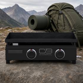 Char-Broil 22-inch tabletop gas griddle on a rock outdoors, black body, two control knobs, mountains behind