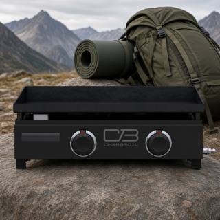 Char-Broil 22-inch tabletop gas griddle on a rock outdoors, black body, two control knobs, mountains behind