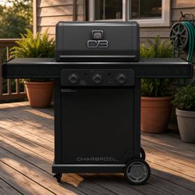 Char-Broil Pro Series 3-burner grill on a timber deck at low sun, lid closed, both side shelves out