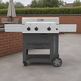 Char-Broil Versa-Tile 28 griddle on a paved patio, stainless lid closed, three knobs, dark cart with two side shelves out