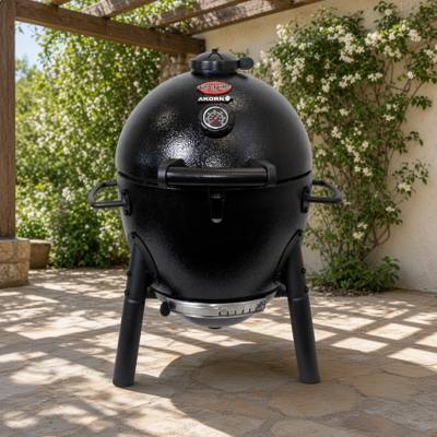 Black Char-Griller AKORN Jr. kamado on three legs on a sunny stone patio