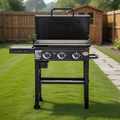 Black Char-Griller 3-burner flat top on a mown lawn, lid raised over bare steel plate, three knobs, shelf folded out