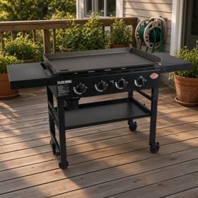 Black Char-Griller Flat Iron four-burner gas griddle on its cart, both side tables out, bare steel plate, on a timber deck