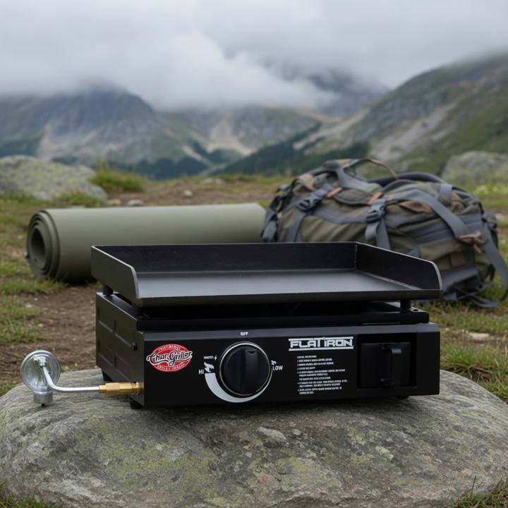 Black Char-Griller Flat Iron portable griddle on a rock at a misty mountain camp, single knob, hose fitted