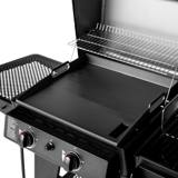 Close view of the flat-top griddle plate seated in the gas side of the FlexFuel Plus, warming rack above it