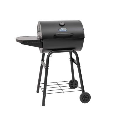 King-Griller Gambler E1416 barrel charcoal grill on its four-leg cart, lid shut, side shelf out, on a stone terrace