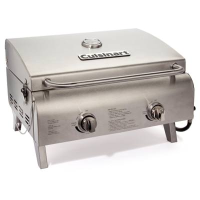 Cuisinart CGG-306P stainless tabletop gas grill, lid closed, standing on a rock outdoors with a backpack behind it