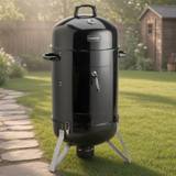Cuisinart COS-118 vertical charcoal smoker, black enamel body on three splayed legs, lid thermometer and latched door.
