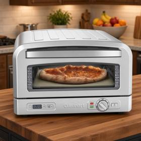 Cuisinart CPZ-120 indoor pizza oven in brushed stainless, a baked pizza on the stone behind the window, dial at right