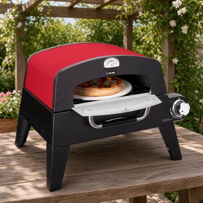 Cuisinart CPO-401 red and black gas pizza oven on a wooden table under a pergola, a pizza on the stone