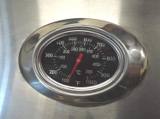 Close-up of the analog hood thermometer, polished oval bezel, dial marked in Celsius and to 1000 Fahrenheit