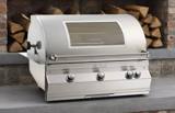 Fire Magic Aurora A790i in a concrete counter inside a brick alcove, hood closed, window and four knobs visible