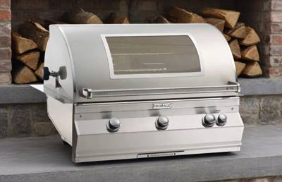 Fire Magic Aurora A790i in a concrete counter inside a brick alcove, hood closed, window and four knobs visible