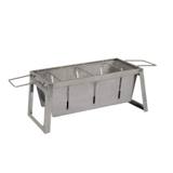 Fire Sense foldaway stainless charcoal grill standing open on its legs, wire grate on top, wire handles hooked at each end