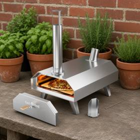 GasOne stainless pellet pizza oven on a stone table by potted herbs, its door and scoop set beside it