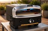 Halo Versa 16 on a steel outdoor table on a deck in evening light, top burner lit above the stone