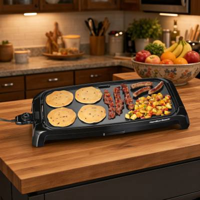 Hamilton Beach 38522 griddle cooking blueberry pancakes, bacon, sausages and diced potatoes, cord entering at the left