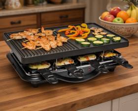 Hamilton Beach 31612MN-MX raclette grill, ribbed and flat plate raised above eight loaded personal trays
