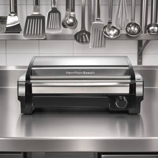 Hamilton Beach 25360 searing grill on a plain background, stainless hood raised above the ribbed nonstick plate