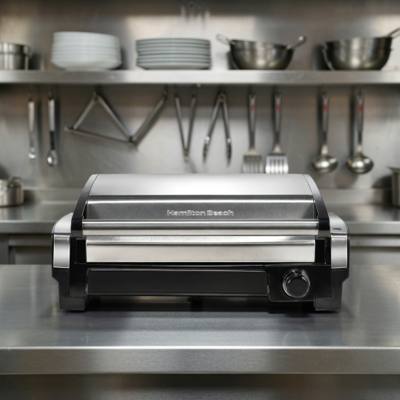 Hamilton Beach 25360 searing grill on a plain background, stainless hood raised above the ribbed nonstick plate