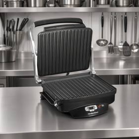 Hamilton Beach 25331 open on a stainless prep bench, both ribbed plates and the lit control strip in view