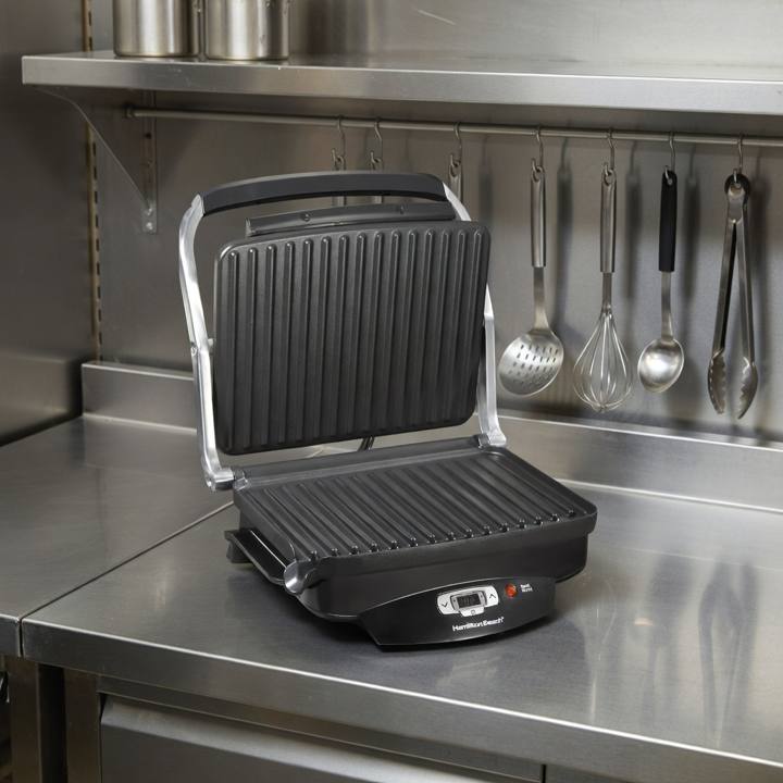 Hamilton Beach 25331 open on a stainless prep bench, both ribbed plates and the lit control strip in view