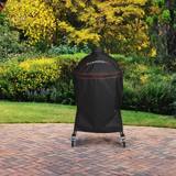 Kamado Joe Big Joe cover over a cart grill on a herringbone brick patio, flowering shrubs behind and casters below the hem