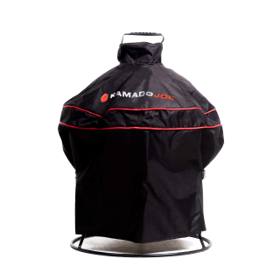 Black Kamado Joe cover with red piping and a top handle over a Joe Jr, its round stand ring visible below