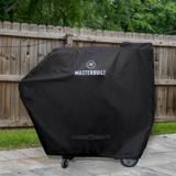 Masterbuilt cover on a Gravity grill on a stone patio, hem cinched just above the wheels, fence behind