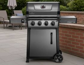 Graphite grey Napoleon Freestyle 425 with four knobs, a closed lid, one cabinet door and both side shelves raised