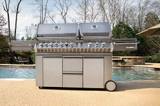 Napoleon Prestige PRO 825 on a poolside patio, twin lids closed and both side shelves extended