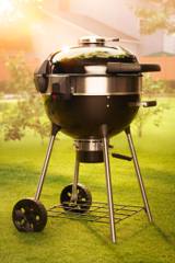 Napoleon PRO22 kettle on a lawn with the optional rotisserie motor clipped to its stainless ring