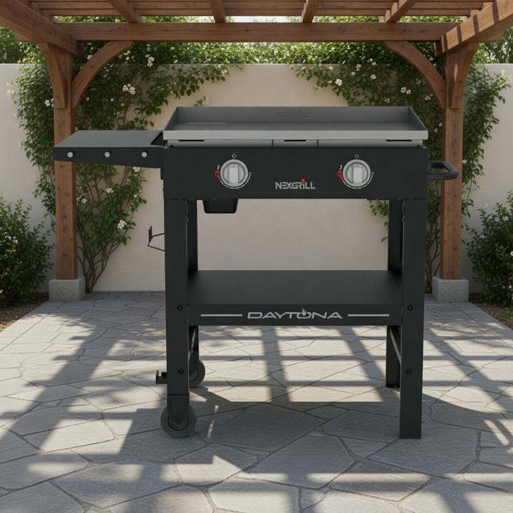 Nexgrill Daytona 28 inch gas griddle on a stone patio under a pergola, flat steel plate, two knobs, one side shelf