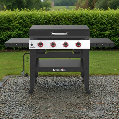 Nexgrill Daytona 4-burner griddle on wet gravel, lid closed, four red knobs on a stainless panel between black shelves